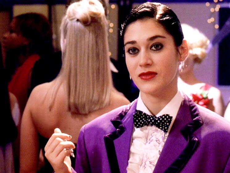 Woman in purple tuxedo looking straight ahead