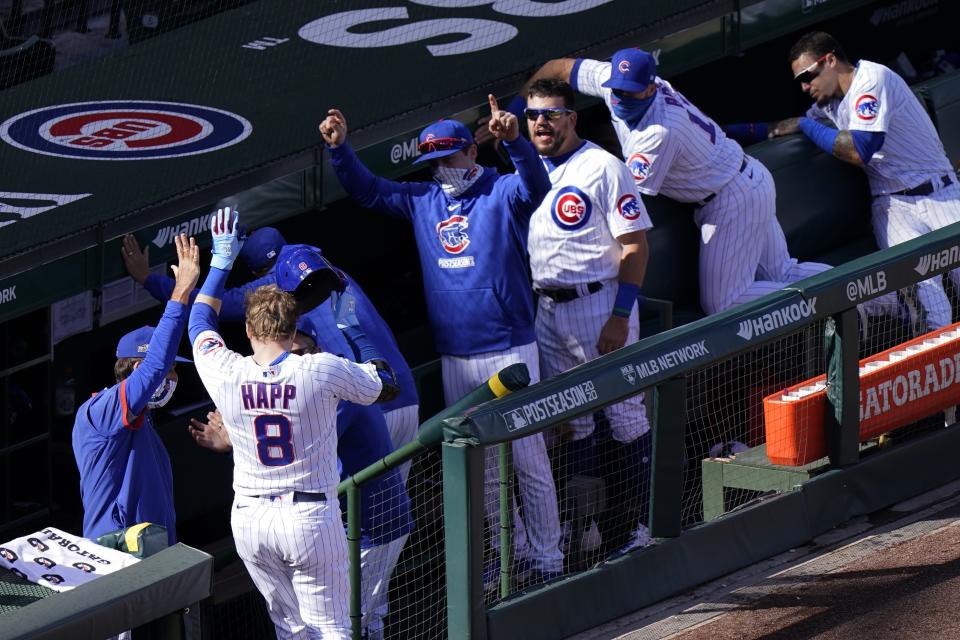 Chicago Cubs' Ian Happ (8) is congratulated at the dugout after hitting a solo home run off of Miami Marlins pitcher Sandy Alcantara in the fifth inning of Game 1 of a National League wild-card baseball series in Chicago, Wednesday, Sept. 30, 2020. (AP Photo/Nam Y. Huh)