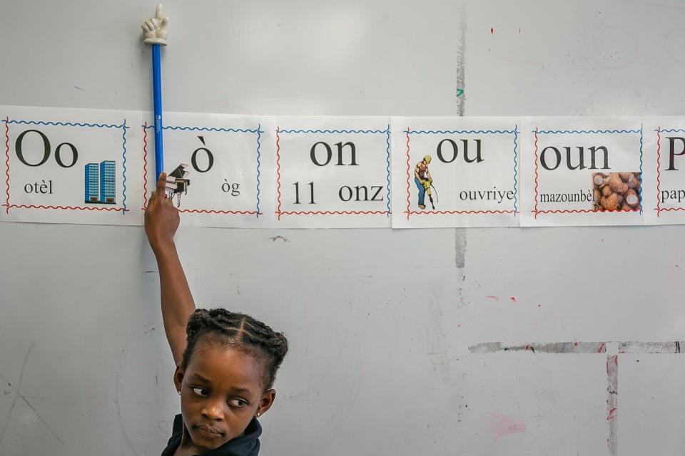 Kyela Pierre points to word pronunciations during class work at Rolling Green Elementary School in Boynton Beach, Fla., on September 1, 2022. The curriculum is taught in Haitian creole. 
