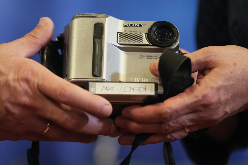 Aye Chan Naing from Democratic Voice of Burma holds the video camera of slain Japanese journalist Kenji Nagai before handing over to his sister Noriko Ogawa, at the Foreign Correspondents Club in Bangkok, Thailand Wednesday, April 26, 2023. Nagai's video camera, which he had been carrying when he was shot dead covering a during a street protest in Myanmar September 2007, was missing until it was recently recovered by the Democratic Voice of Burma news service, which handed it over to his sister at the club. (AP Photo/Sakchai Lalit)