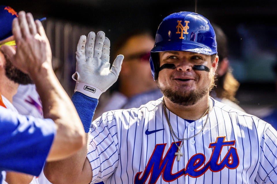 New York Mets' Daniel Vogelbach high-ives teammates in the dugout after hitting a home run during the sixth inning of a baseball game against the Philadelphia Phillies, Sunday, Aug. 14, 2022, in New York. (AP Photo/Julia Nikhinson)