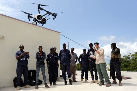 Somali police officers watch instructor Brett Velicovich (2nd R) fly a DJI Inspire drone during a drone training session for Somali police in Mogadishu, Somalia May 25, 2017. REUTERS/Feisal Omar