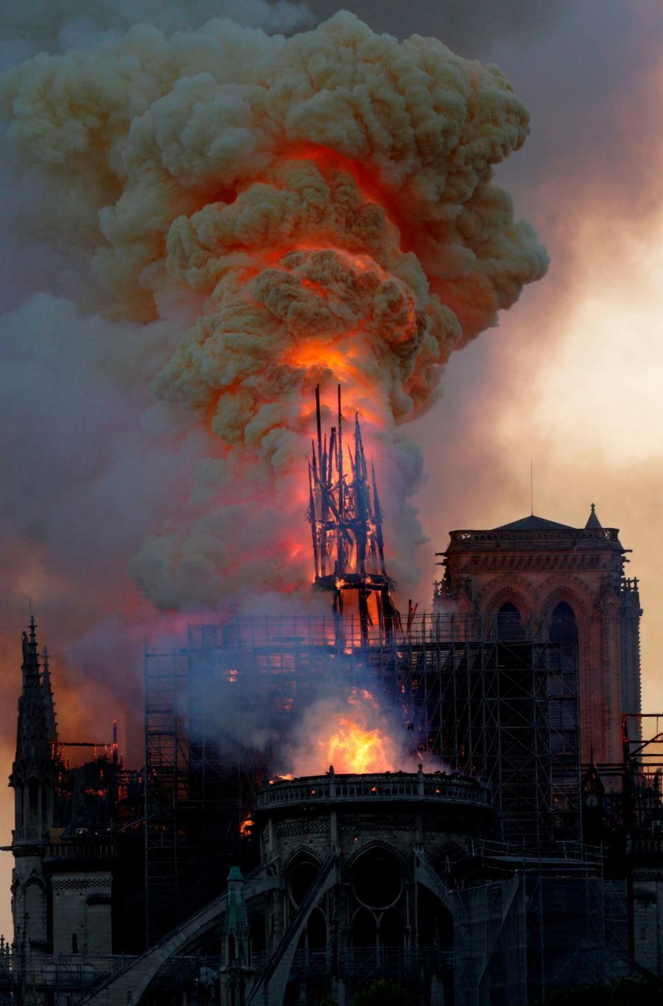 The steeple of Notre Dame collapses as the iconic cathedral burns on April 15, 2019, in Paris.