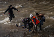 Paramedics and demostrators attend a youth who fell into the Mapocho river from a bridge during a police charge on protesters in Santiago, Chile, Friday Sept.2, 2020. The incident unleashed a wave of criticism against police for the repression during demonstrations and the government repudiated the acts of violence condemning "categorically any action that violates human rights". The young man is in a hospital in serious but stable condition, according to the latest medical reports. (AP Photo/Aliosha Marquez Alvear)