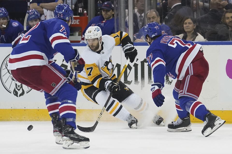 Pittsburgh Penguins right wing Bryan Rust (17) breaks against the New York Rangers defense during the third period of NHL hockey game Thursday, April 7, 2022, in New York. (AP Photo/Bebeto Matthews)