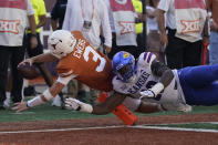 Texas quarterback Quinn Ewers (3) dives past Kansas defensive lineman Jereme Robinson (90) for a touchdown during the second half of an NCAA college football game in Austin, Texas, Saturday, Sept. 30, 2023. (AP Photo/Eric Gay)