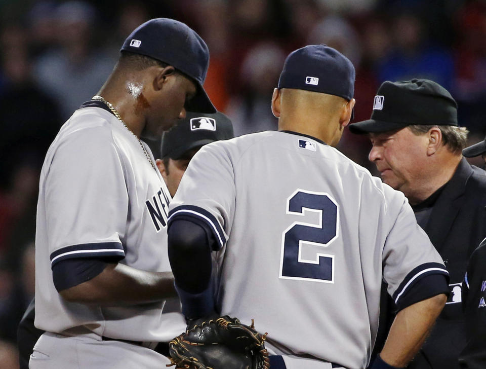 Home plate umpire Gerry Davis, right, confers on the mound with New York Yankees starting pitcher Michael Pineda, left; shortstop Derek Jeter (2); and others in the second inning of a baseball game against the Boston Red Sox at Fenway Park in Boston, Wednesday, April 23, 2014. Pineda was ejected after umpires found with a foreign substance on his neck.(AP Photo/Elise Amendola)