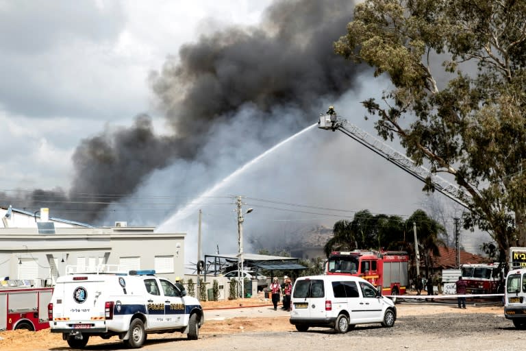 Israeli firefighters douse flames after a fire at a fireworks warehouse in Porat village killed at two people on March 14, 2017