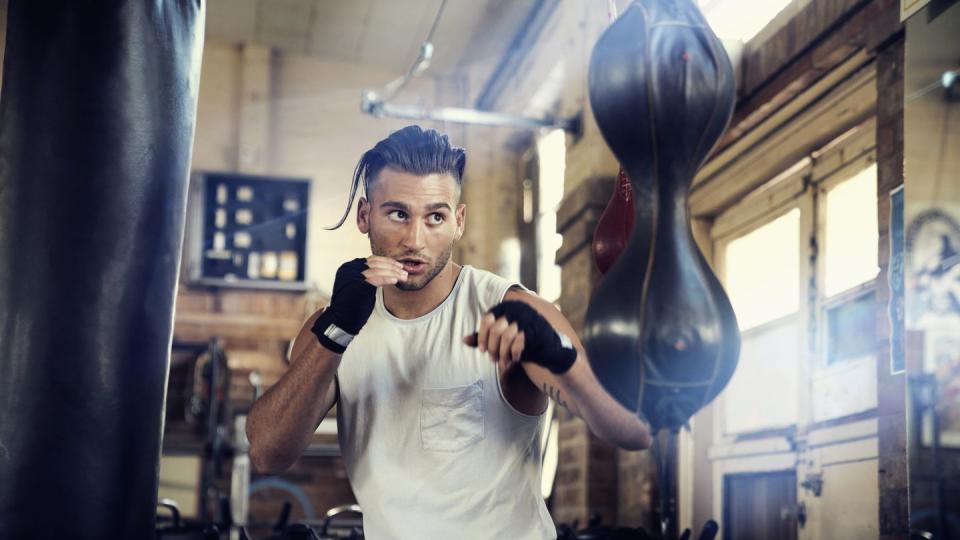 Hispanic man punching speed bag in gymnasium