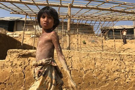 A Rohingya refugee child works on a new house at Kutupalang Unregistered Refugee Camp in Cox's Bazar, Bangladesh, February 27, 2017. REUTERS/Stringer