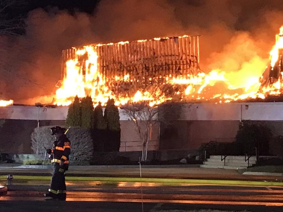 A firefighter passes the blazing church at Fountain of Life Center in Florence on March 20, 2023.