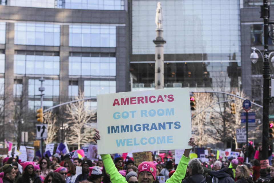 A demonstrator holds a sign that reads 'America's Got Room Immigrants Welcome' at Columbus Circle during the Women's March on New York City in New York, U.S., on Saturday, Jan. 20, 2018. One year after the inauguration of President Donald Trump, thousands of people will again gather to protest for equal rights at the 2018 Women's March. Photographer: Jeenah Moon/Bloomberg via Getty Images