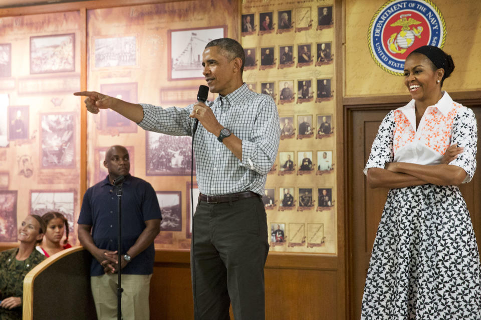 President Obama, with first lady Michelle Obama, points toward a child in the audience as he greets troops and their families on Christmas Day, Thursday, Dec. 25, 2014, at Marine Corps Base Hawaii in Kaneohe Bay, Hawaii.. (AP Photo/Jacquelyn Martin)