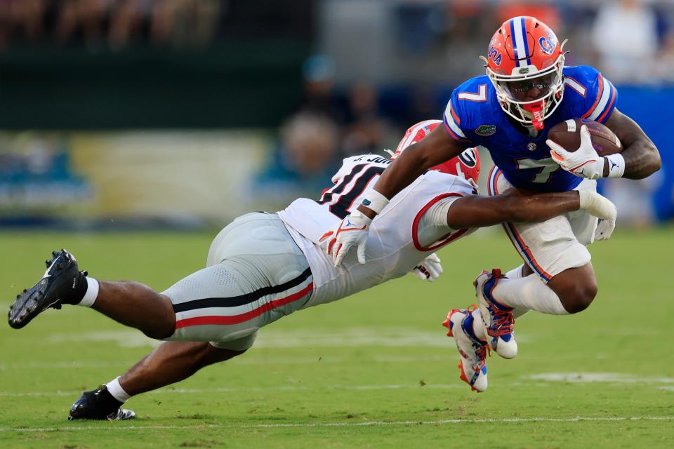 Georgia linebacker Jamon Dumas-Johnson, left, tackles Florida running back Trevor Etienne in a game last season. The one-time All-American for Georgia has transferred to SEC rival Kentucky, bolstering an already stout Wildcats linebackers unit.