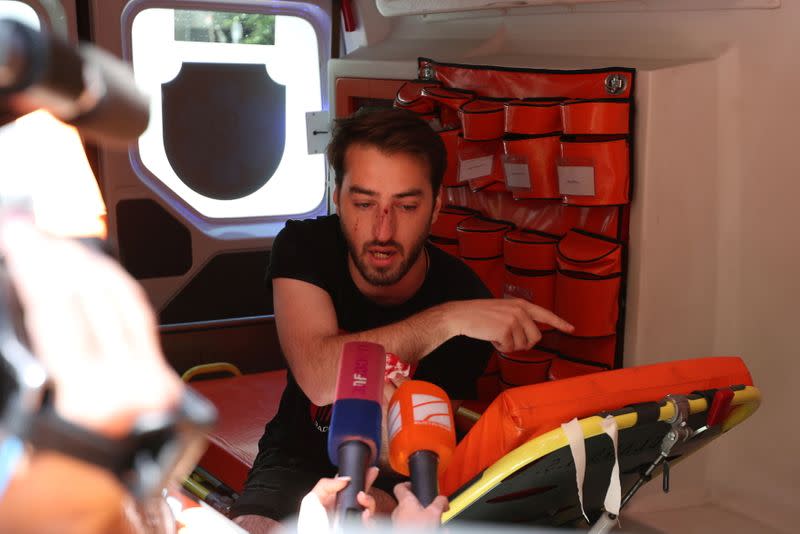 A journalist injured at a rally against the March for Dignity speaks to the media inside an ambulance in Tbilisi