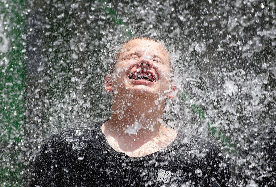 <p>A young boy finds some relief from the heat under a cascading waterfall feature at the Wet-N-Wild Water Park on June 20, 2017 in Phoenix, Arizona. (Ralph Freso/Getty Images) </p>