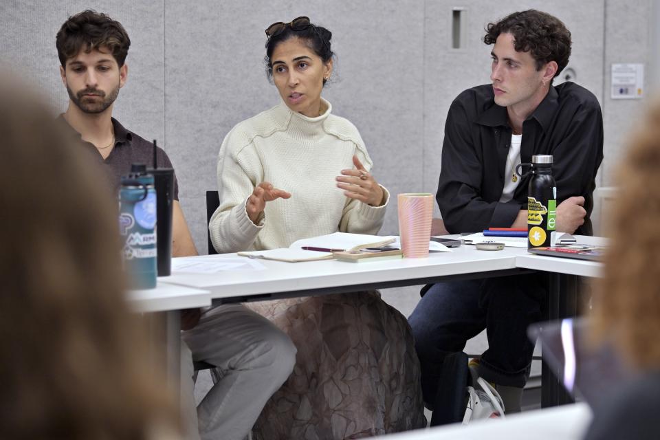 Leyla Uysal, a design school student from Harvard University with an urban planning background, center, speaks during a course concerning the conflicts that arise in the siting process of renewable energy projects, at the Massachusetts Institute of Technology, Friday, Sept. 15, 2023, in Cambridge, Mass. Mike Giovanniello, left, and Kailin Graham listen to the discussion. "It's going to be difficult, but I will educate myself not to take sides," Uysal said. (AP Photo/Josh Reynolds)