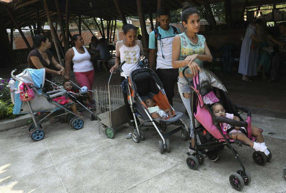 In this Feb. 4, 2019 photo, Venezuelan migrants line up with their children for a free lunch served at the "Amigos Del Projimo" migrant shelter, in La Parada, on the outskirts of Cucuta, Colombia, on the border with Venezuela. Caritas, a charity run by the Roman Catholic church, estimates that child malnutrition more than doubled last year in Venezuela due to widespread food shortages and 7-digit hyperinflation, while 48 percent of pregnant women in low-income neighborhoods are also underfed. (AP Photo/Fernando Vergara)