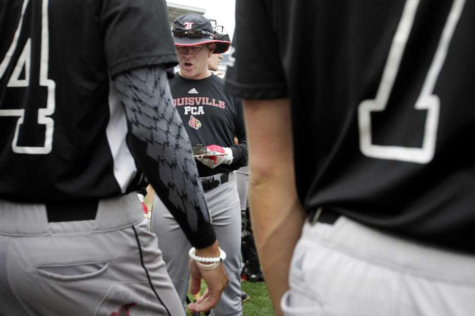 Louisville head coach Dan McDonnell talks with his players during practice for baseball's College World Series at TD Ameritrade Park, Friday, June 14, 2019, in Omaha, Neb. (Ryan Soderlin/Omaha World-Herald via AP)