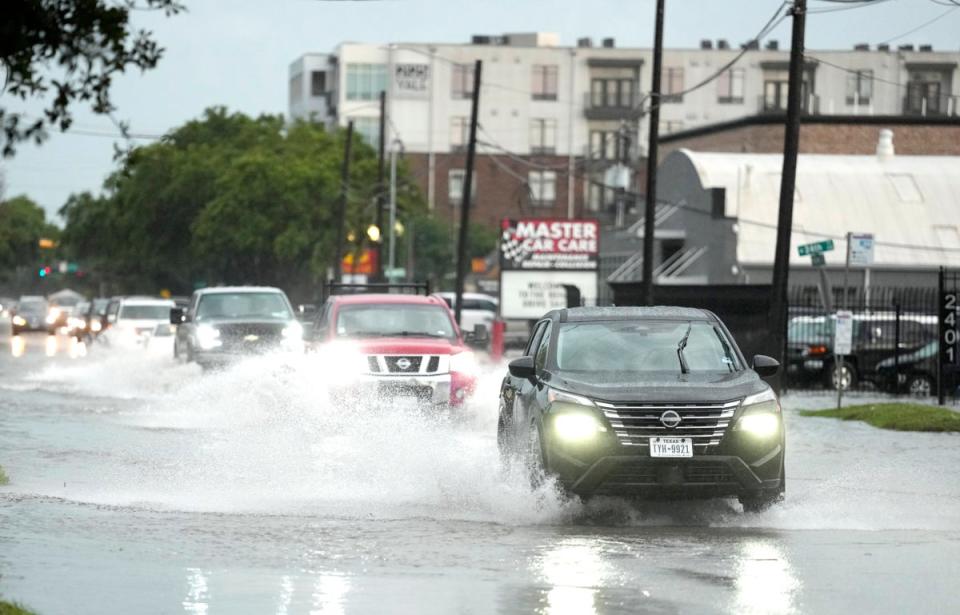 Drivers navigate high water on a Houston, Texas street as severe thunderstorms pelt the state (AP)