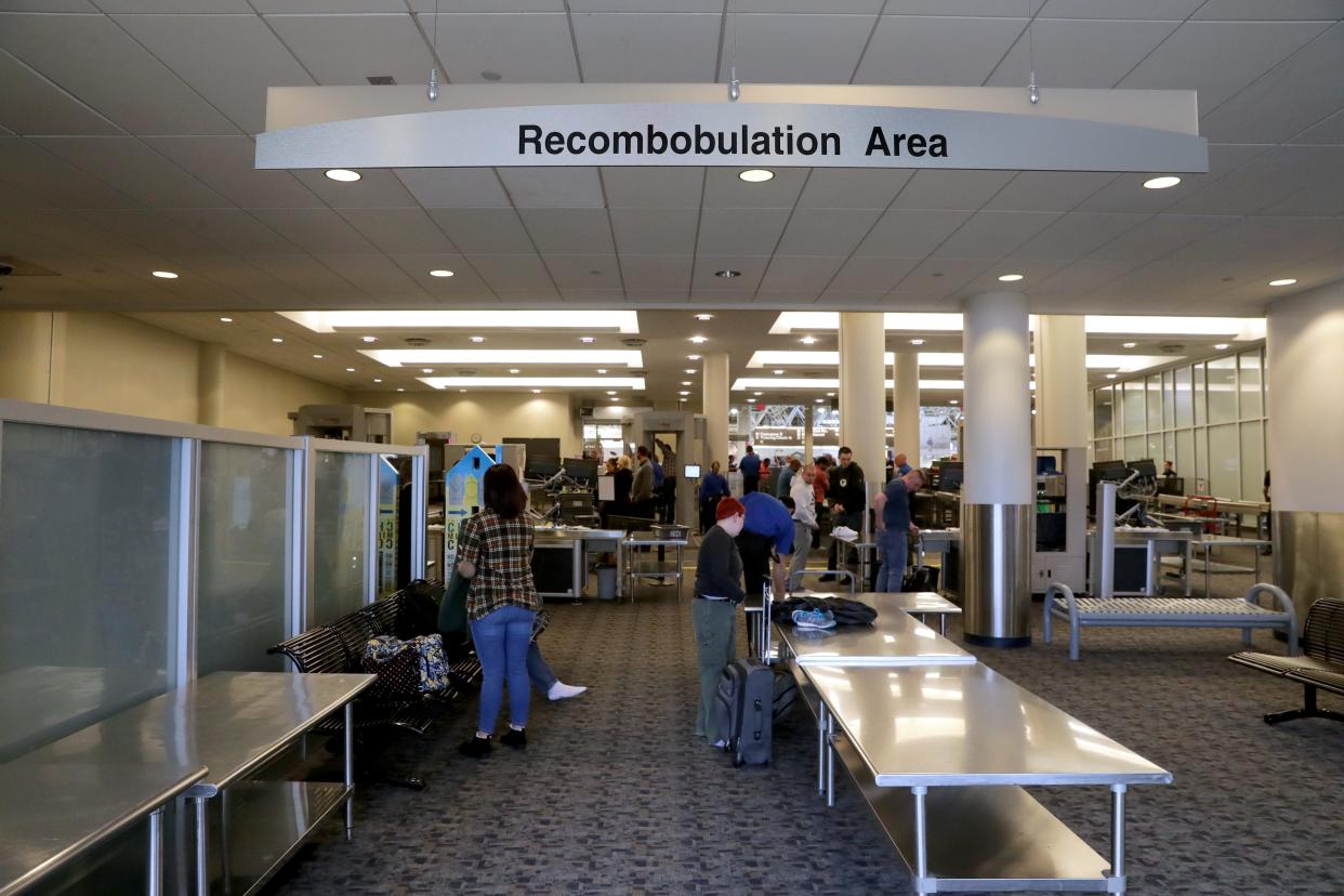 Travelers organize their belongings after screening in the "recombobulation area" at Mitchell International Airport.