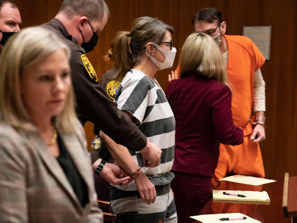 Oakland County Prosecutor Karen McDonald, left, stands as a deputy unlocks the shackles of Jennifer Crumbley, who stands to the left of attorney Mariell Lehman as her husband, James Crumbley sat to the right in the Oakland County courtroom of Judge Cheryl Matthews on March 22, 2022, regarding pretrial matters.