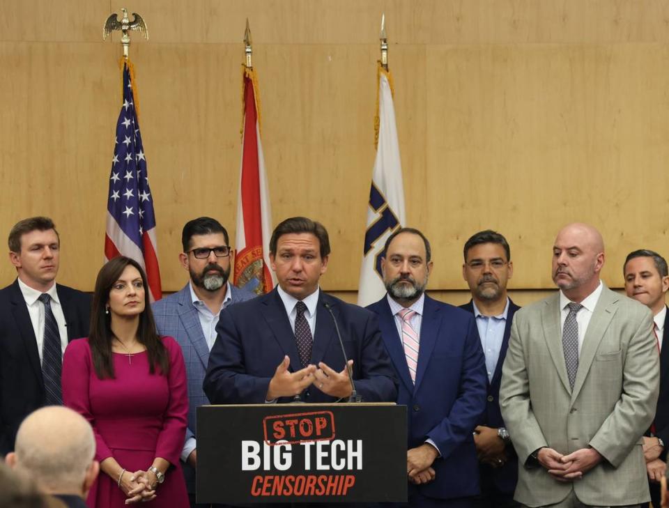 El lunes 25 de mayo de 2021 en Miami, el gobernador Ron DeSantis pronuncia un discurso de apertura flanqueado por legisladores locales antes de firmar la legislación que dificultará a las empresas de redes sociales castigar a los usuarios que violen los términos de los acuerdos de servicio.