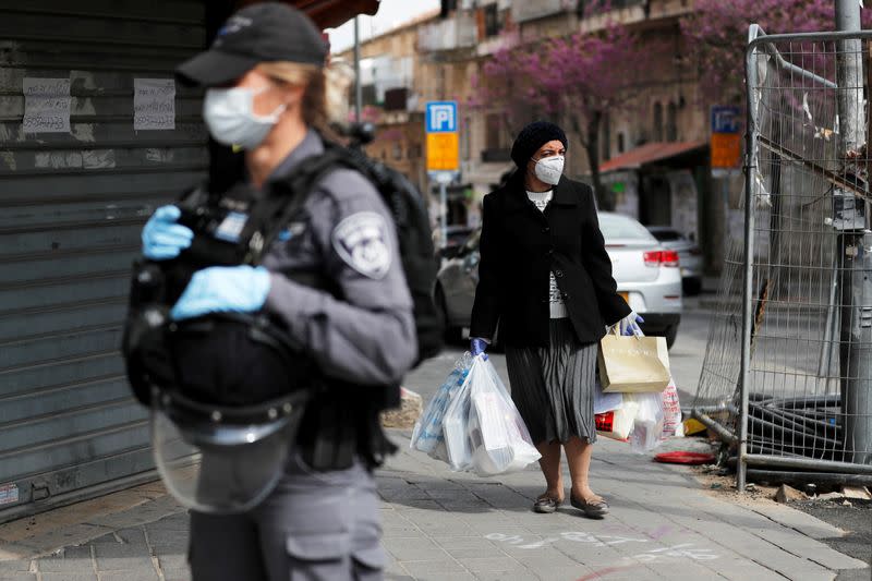 An ultra-Orthodox Jewish woman wears a mask near an Israeli policewoman as she patrols to enforce a national lockdown to fight the spread of the coronavirus disease (COVID-19) in Mea Shearim neighbourhood of Jerusalem