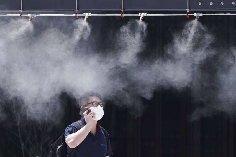 東京的商家雖然設有噴霧裝置，還是擋不住盛夏的酷暑。（美聯社）