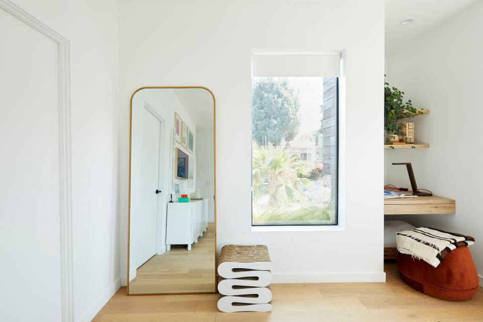 Interior of the primary bedroom and office nook. The mirror is by Crate & Barrel and the Vitra Wiggle stool by Frank Gehry was custom fabricated.