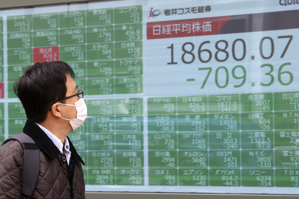A man looks at an electronic stock board of a securities firm in Tokyo, Monday, March 30, 2020. Asian shares started the week with further losses as countries reported surging numbers of infections from the coronavirus that has prompted shutdowns of travel and business in many parts of the world.(AP Photo/Koji Sasahara)
