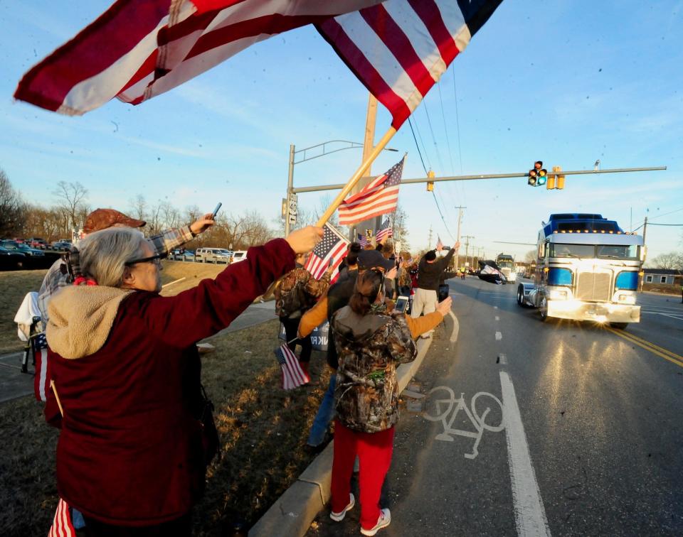 Barbara Beauchamp of Hagerstown waves an American flag at The People's Convoy rolls along U.S. 40 at Greencastle Pike Friday.