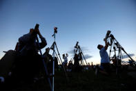 People watch the solar eclipse over Carhenge in Alliance, Neb., U.S. August 21, 2017. Location coordinates for this image are 42°8'33"N 102°51'29"W. REUTERS/Scott Morgan