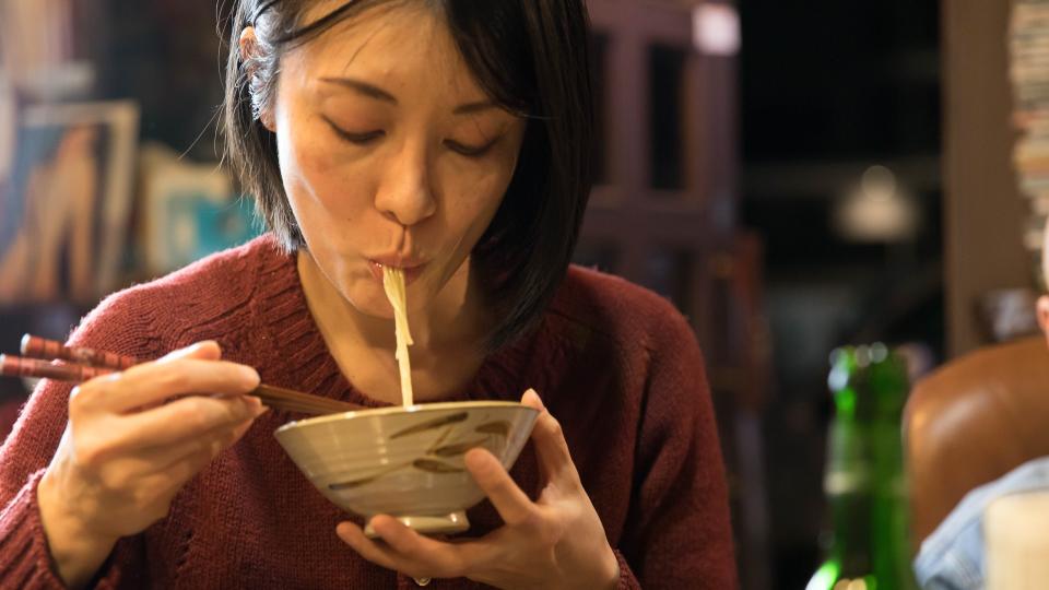 Mid woman eating noodle.