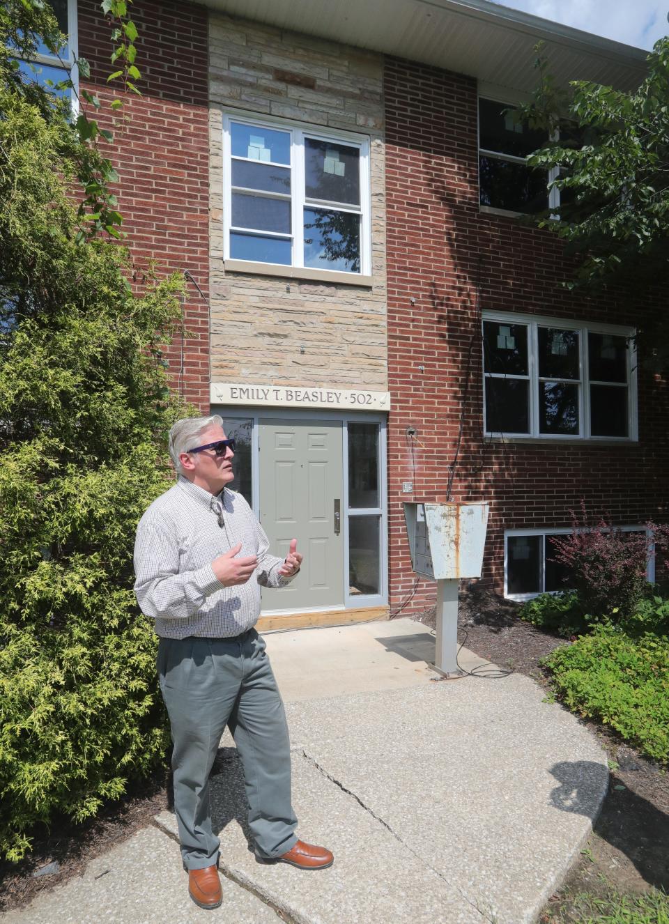 Fred Berry, president and CEO of Humility of Mary Housing, talks Wednesday in front of the fire-damaged six-unit apartment building that the organization operates to assist homeless families on Treeside Drive in Northwest Akron.