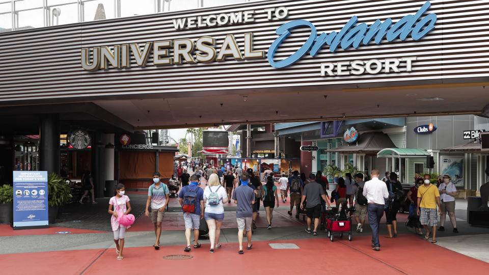 In this Wednesday, June 3, 2020 photo, visitors arrive at Universal Studios Wednesday, June 3, 2020, in Orlando, Fla. The Universal Studios theme park has reopened for season pass holders and will open to the general public on Friday, June 5. (AP Photo/John Raoux)