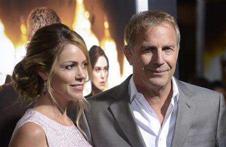 Cast member Kevin Costner (R) and wife Christine Baumgartner attend the premiere of the film "Jack Ryan: Shadow Recruit" in Los Angeles January 15, 2014. REUTERS/Phil McCarten