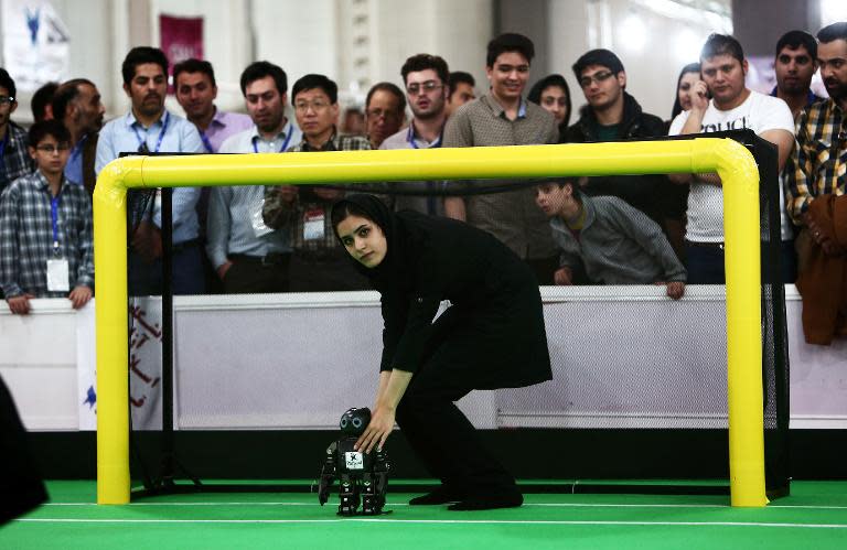 Bahareh Forough of 'Mechatronics Research Laboratory' from Iran's Azad University of Qazvin adjusts a goalkeeper robot during the RoboCup Iran Open 2014, in Tehran, on April 10