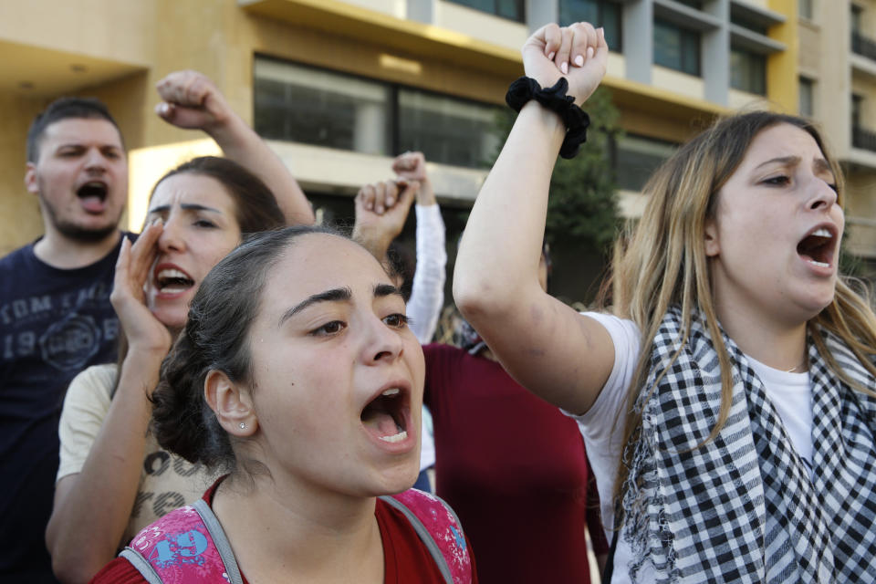 Anti-government protesters chant "Revolution" after Lebanon Prime Minister Saad Hariri announced he is submitting his resignation, meeting one of their main demands, in front of the government palace in Beirut, Lebanon, Tuesday, Oct. 29, 2019. The protesters have been on the streets for 13 days, calling for the government to resign and accusing longtime politicians of corruption. (AP Photo/Bilal Hussein)