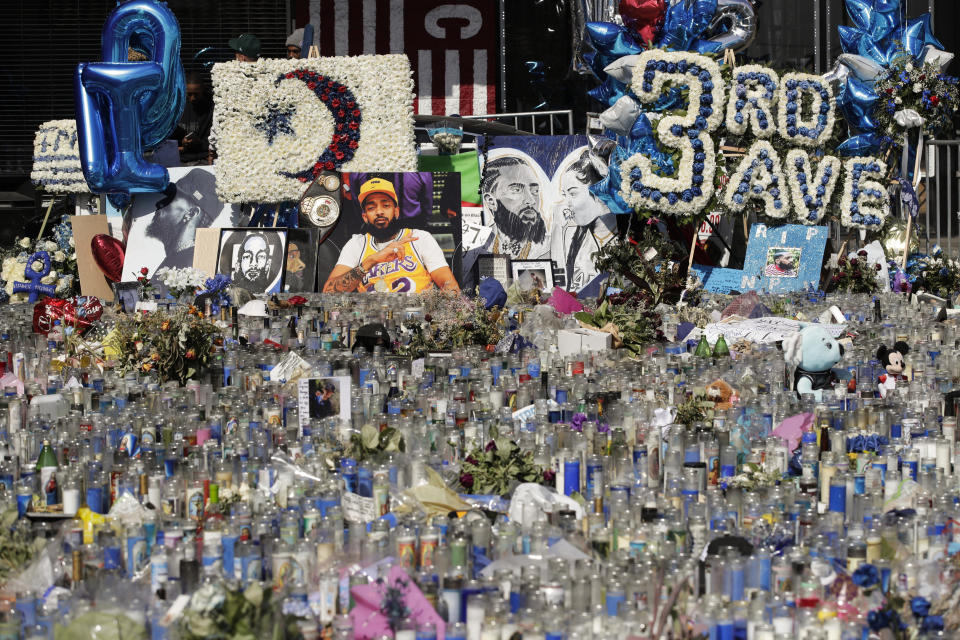 FILE - In thie April 11, 2019 file photo, a makeshift memorial site for slain rapper Nipsey Hussle is filled with candles outside The Marathon Clothing store in Los Angeles. Hussle, 33, was shot and killed outside his Los Angeles clothing store in Los Angeles on March 31, 2019. A year after Hussle's death, his popularity and influence are as strong as ever. He won two posthumous Grammys in January, he remains a favorite of his hip-hop peers and his death has reshaped his hometown of Los Angeles in some unexpected ways. (AP Photo/Jae C. Hong, File)