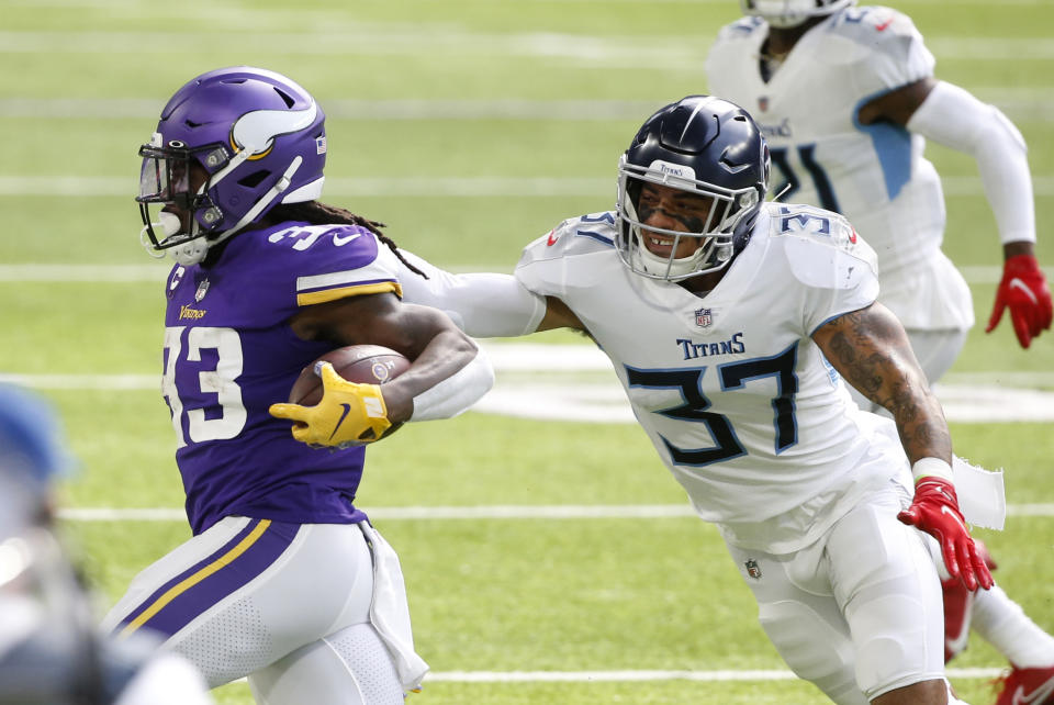 Minnesota Vikings running back Dalvin Cook (33) tries to break a tackle by Tennessee Titans safety Amani Hooker (37) during the first half of an NFL football game, Sunday, Sept. 27, 2020, in Minneapolis. (AP Photo/Bruce Kluckhohn)