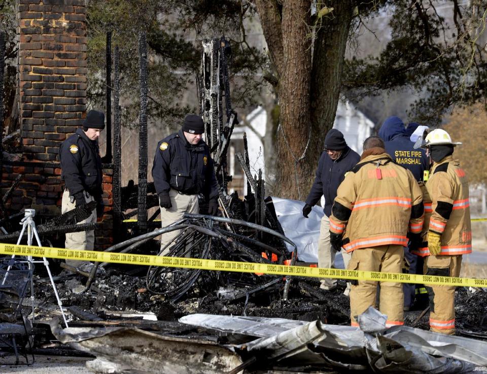 Kentucky State Fire investigators work at the scene of early morning house fire in Depoy, Ky. Thursday Jan. 30, 2014. As many as nine people were killed early Thursday in a house fire in rural western Kentucky and two people were taken to a hospital for treatment, officials said. Eleven people lived in the home in the Depoy community of Muhlenberg County, Greenville Assistant Fire Chief Roger Chandler said. (AP Photo/Timothy D. Easley)