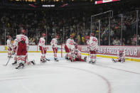 Boston University players sit and stand on the ice after an overtime loss to Denver in a semifinal game at the Frozen Four NCAA college hockey tournament Thursday, April 11, 2024, in St. Paul, Minn. (AP Photo/Abbie Parr)