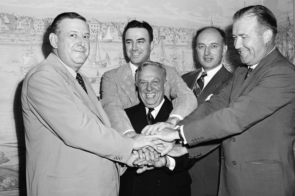 FILE - In this Aug 3, 1949, file photo, representatives of the National Basketball League and Basketball Association of America, shake hands after agreeing to a merger of the two circuits into an 18-team organization to be known as the National Basketball Association New York. Grouped around Maurice Podoloff, center, are left to right, Ike Duffey, Leo Ferris, Ned Irish and Walter Brown. (AP Photo/John Lent, File)