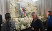 Fans file past a wall of flowers with a portrait of Denver Broncos owner Pat Bowlen placed in the center during a memorial Tuesday, June 18, 2019, at Mile High Stadium, the NFL football team's home in Denver. Bowlen, who has owned the franchise for more than three decades, died last Thursday. (AP Photo/David Zalubowski)