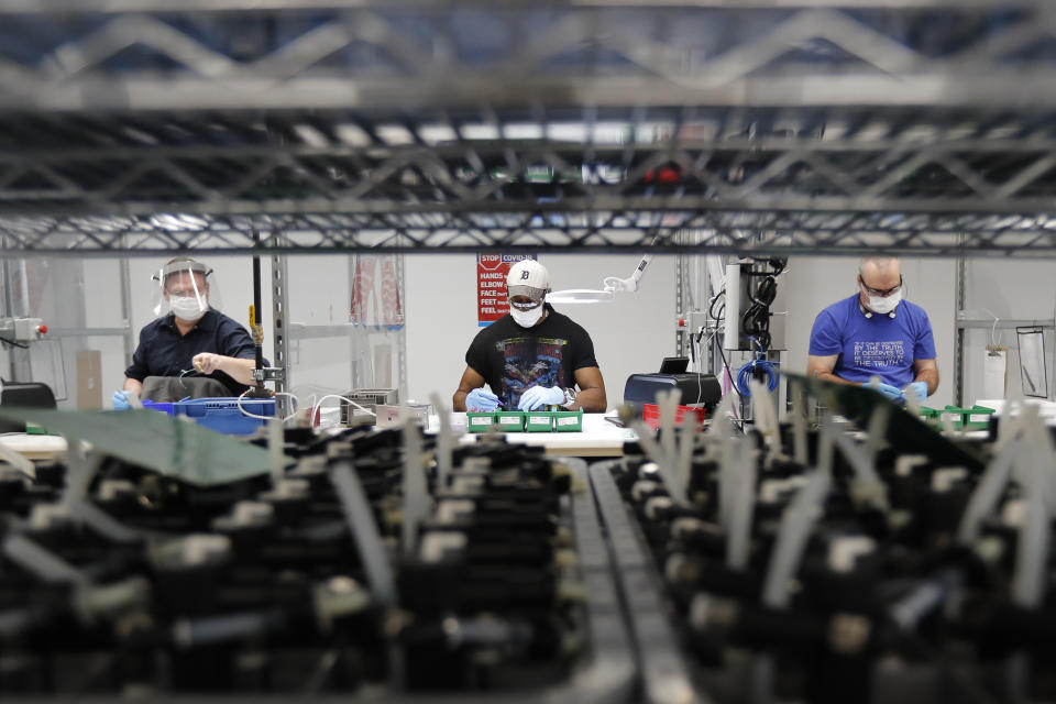 Ford Motor Co., line workers put together ventilators that the automaker is assembling at the Ford Rawsonville plant, Wednesday, May 13, 2020 in Ypsilanti Township, Mich. The plant was converted into a ventilator factory, as hospitals battling the coronavirus report shortages of the life-saving devices. The company has promised to deliver 50,000 by July 4. (AP Photo/Carlos Osorio)