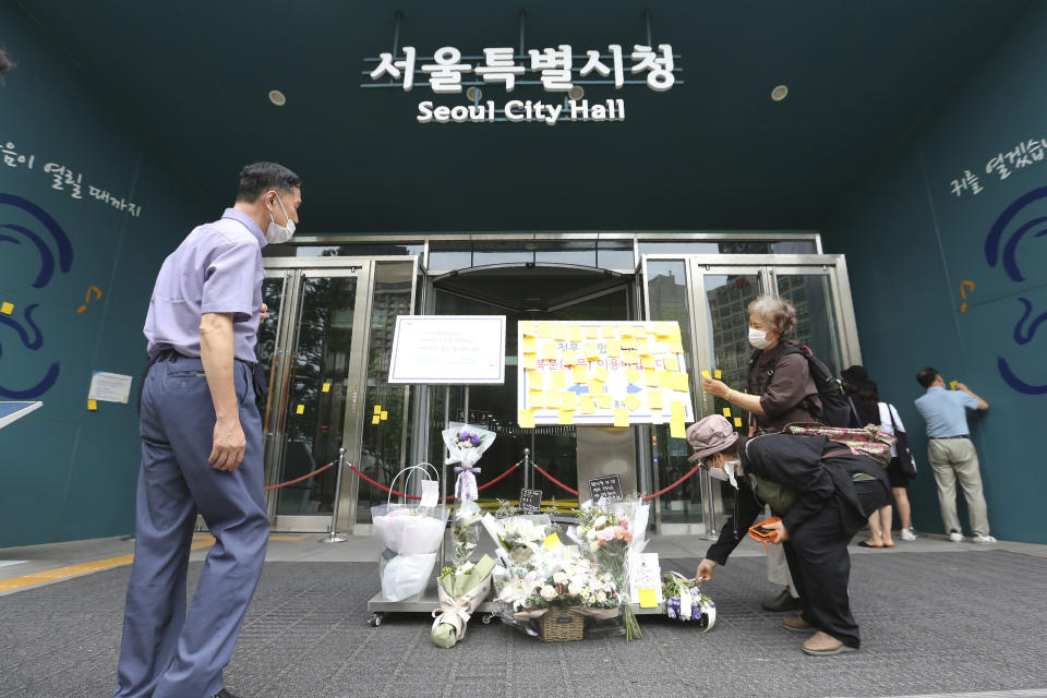 A mourner attaches condolence messages on a paper note for late Seoul Mayor Park Won-soon at a board in front of City Hall in Seoul, South Korea, Sunday, July 12, 2020. The sudden death of Seoul's mayor, reportedly implicated in a sexual harassment complaint, has prompted an outpouring of public sympathy even as it has raised questions about a man who built his career as a reform-minded politician and self-described feminist. (AP Photo/Ahn Young-joon)