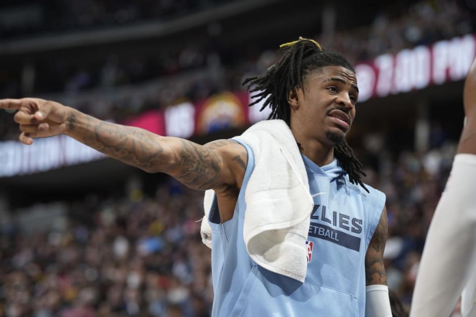 Memphis Grizzlies guard Ja Morant talks with teammates on the bench in the first half of an NBA basketball game against the Denver Nuggets, Friday, March 3, 2023, in Denver. (AP Photo/David Zalubowski)