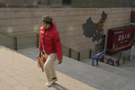 A woman walks through a partially shuttered Evergrande commercial complex in Beijing, Monday, Jan. 29, 2024. Chinese property developer China Evergrande Group on Monday was ordered to liquidate by a Hong Kong court, after the firm was unable to reach a restructuring deal with creditors. (AP Photo/Ng Han Guan)