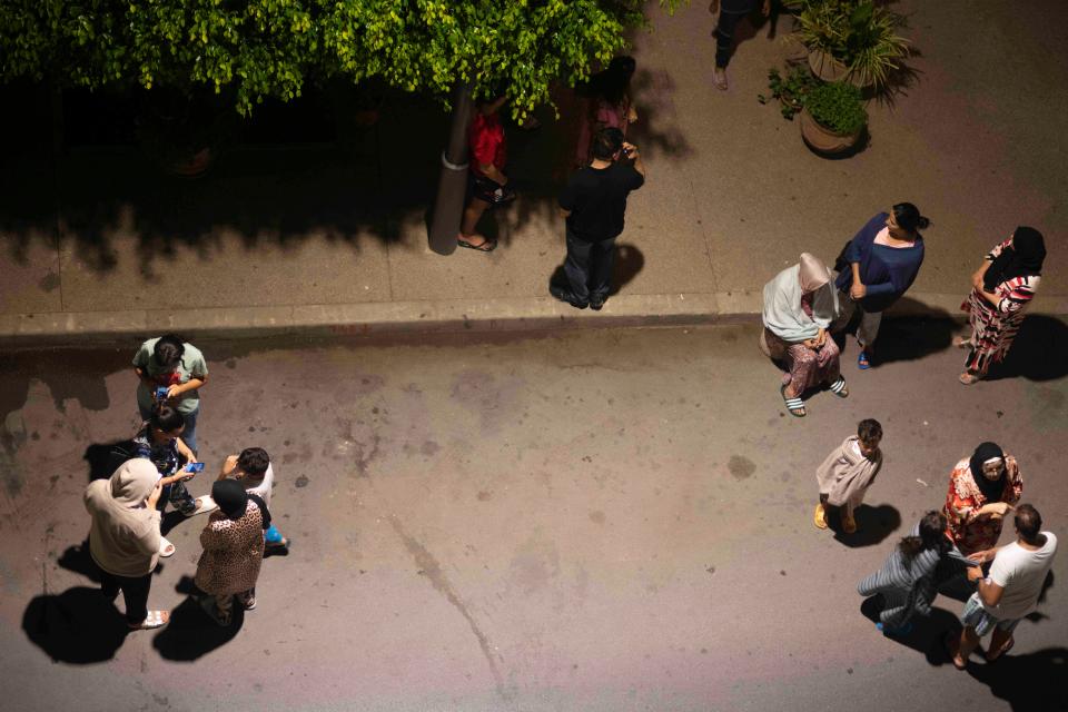 People take shelter and check for news on their mobile phones after an earthquake in Rabat, Morocco, Friday, Sept. 8, 2023. A powerful earthquake struck Morocco late Friday, damaging buildings in major cities and sending panicked people pouring into streets and alleyways from Rabat to Marrakech.
